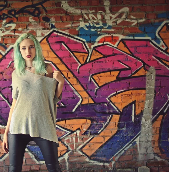 Girl posing near the wall with graffiti