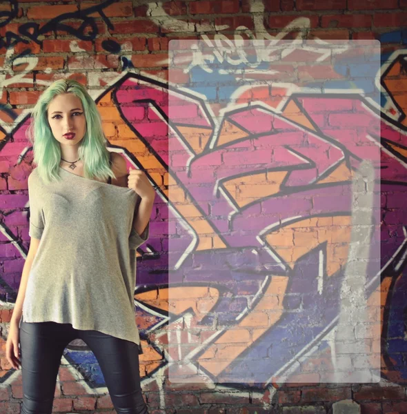 Girl posing near the wall with graffiti