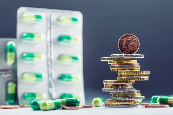 Euro money and medicaments. Eurocoins and pills. Coins stacked on each other in different positions and freely pills scattered around. Reimbursement of medicinal products in health care