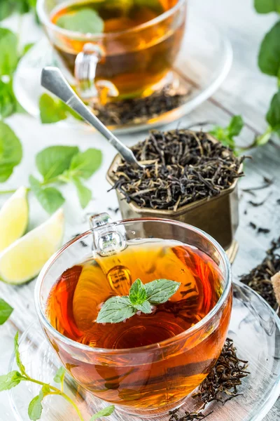 Tea. Mint Tea. Herbal tea. Mint leaf. Mint leaves. Tea in a glass cup, mint leaves, dried tea, sliced lime. herbs tea and mint leaves on a slate plate in a restaurant or teahouse tea room