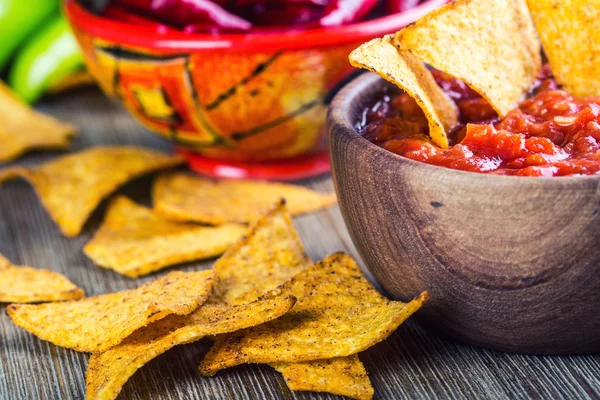 Salsa with tortilla chips and chilli peppers.Macro concept