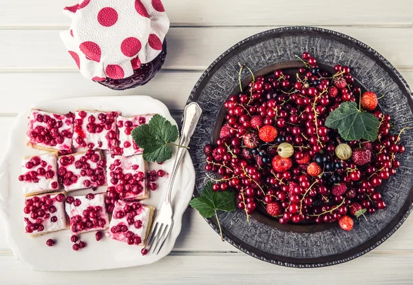 Red currant sponge cake. Plate with Assorted summer berries, raspberries, strawberries, cherries, currants, gooseberries.