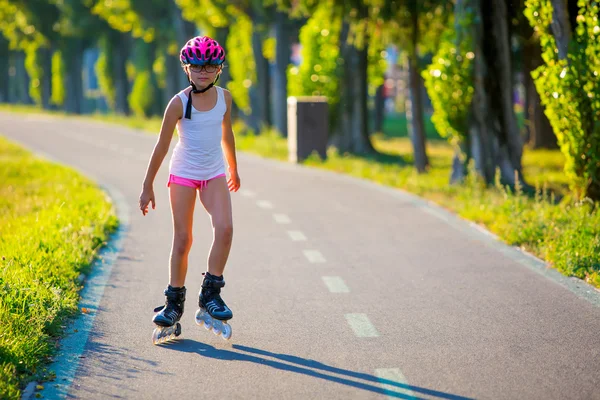 Rollerblading. Roller skating young girl in park rollerblading on inline skates.