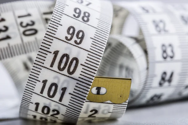 Curved measuring tape. Measuring tape of the tailor. Closeup view of white measuring tape