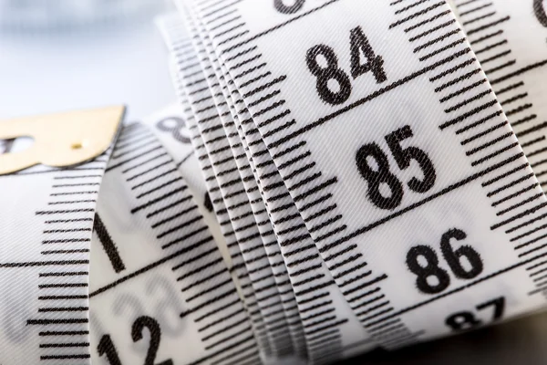 Curved measuring tape. Measuring tape of the tailor. Closeup view of white measuring tape