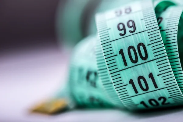 Urved measuring tape. Measuring tape of the tailor. Closeup view of Green measuring tape