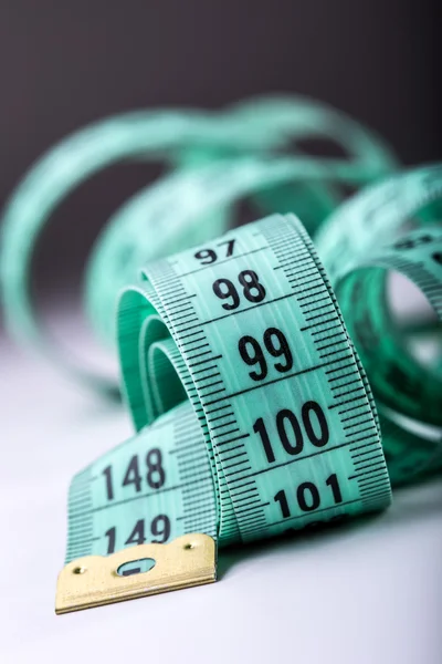 Urved measuring tape. Measuring tape of the tailor. Closeup view of Green measuring tape