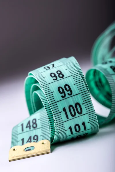 Urved measuring tape. Measuring tape of the tailor. Closeup view of Green measuring tape