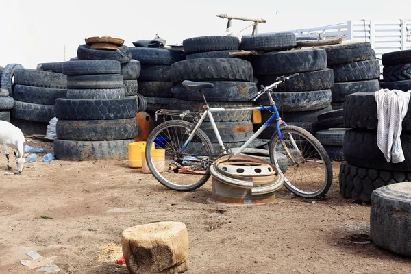 Mountain bike leaning on truck rim. Afrera town-Ethiopia. 0175