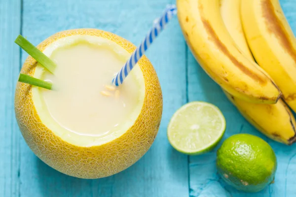 Exotic freshly squeezed juice with banana yellow melon and lime