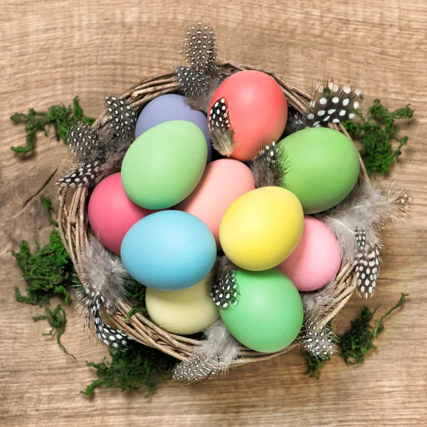 Easter eggs with feather decoration in basket