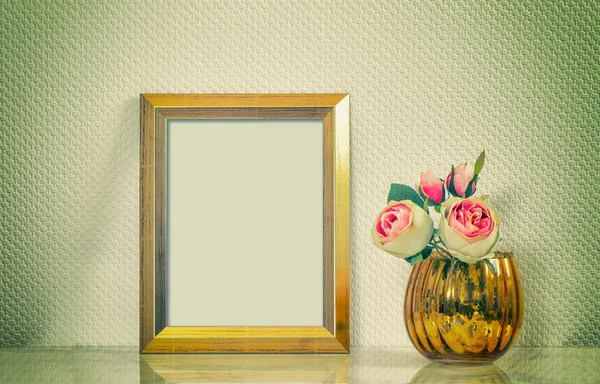 Picture mock up with golden frame amd flowers. Retro toned