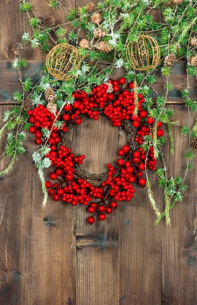 Green christmas tree branches and wreath from red berries