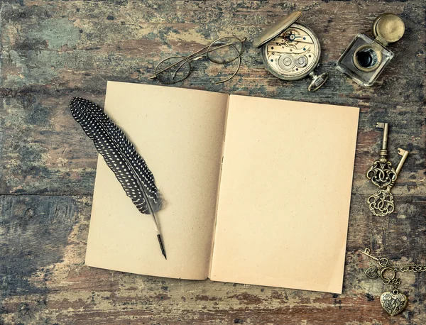 Open book and vintage writing accessories. Wooden texture backgr