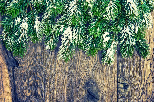 Christmas tree branches on rustic wooden background. Vintage sty