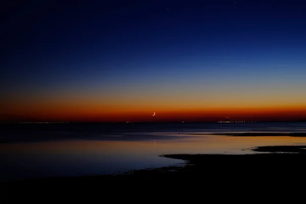 Sunset over the sea and the moon