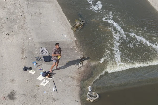 Homeless man washes in river