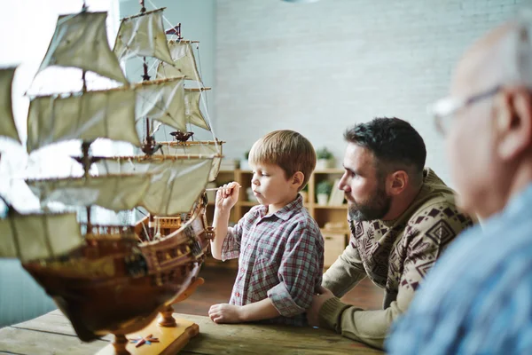 Boy painting toy ship