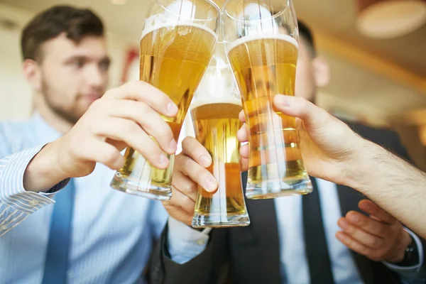 Businessmen toasting with beer