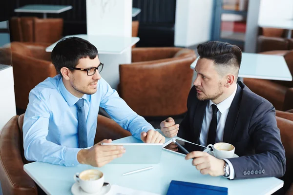 Businessmen planning work together in cafe