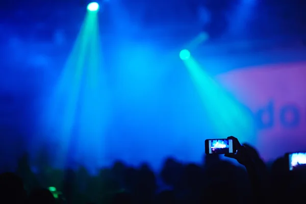 Hands recording video during concert