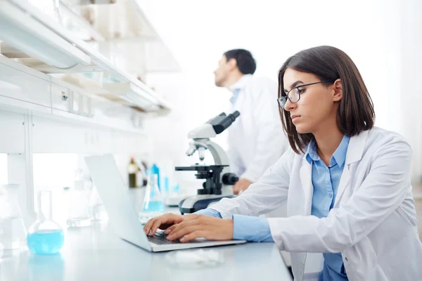 Female scientist typing in lab