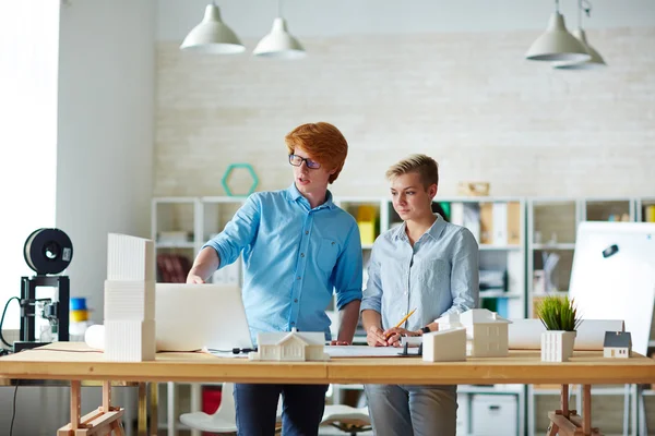 Young designer explaining his co-worker