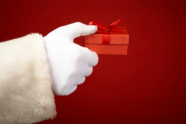 Santa Claus hand holding gift box