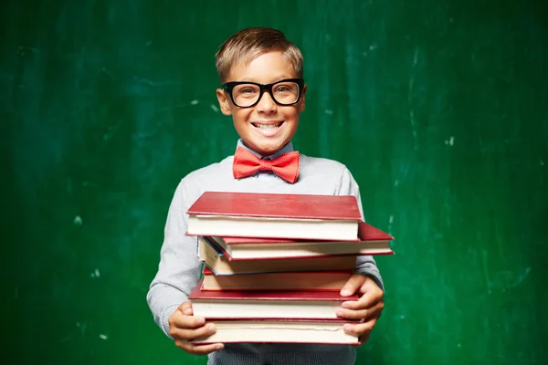 Pupil holding stack of textbooks