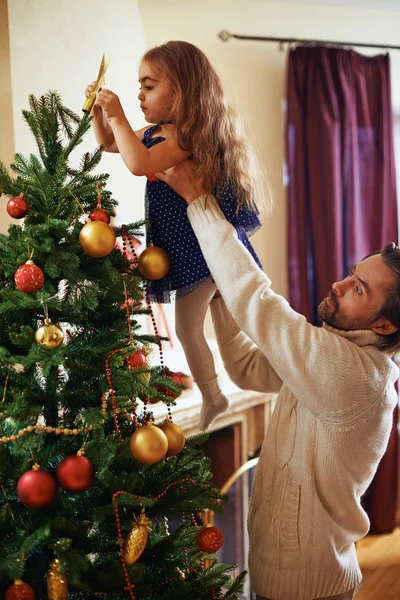 Father  and daughter decorating Christmas tree