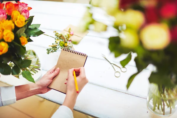 Florist with pencil making notes