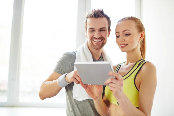 Sporty couple using touchpad