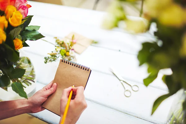 Florist with pencil making notes