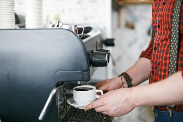 Barista making coffee in coffee machine