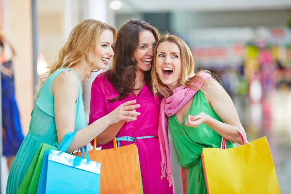 Women with paper bags laughing in mall