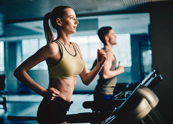 Woman and man running on treadmill