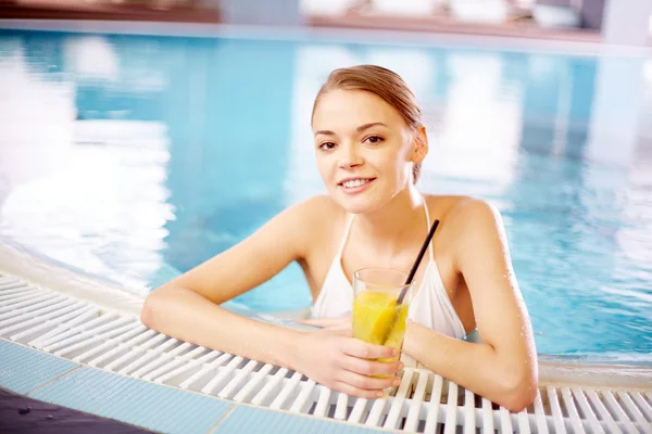 Woman with juice in swimming pool