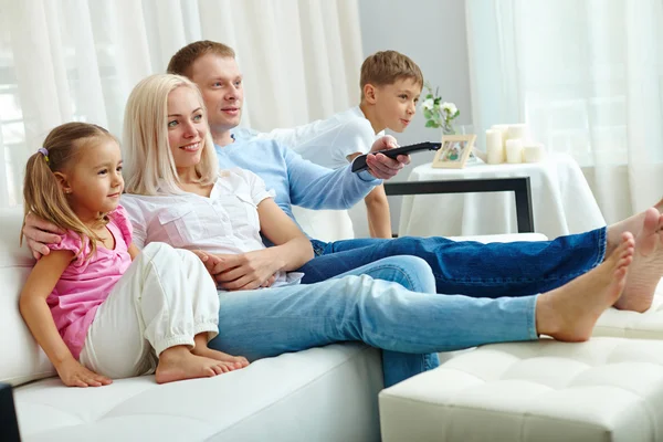 Family watching TV at home