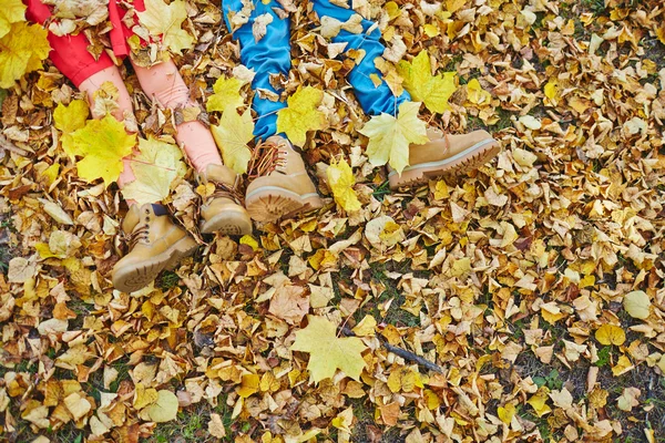 Kids legs in boots  on autumn leaves