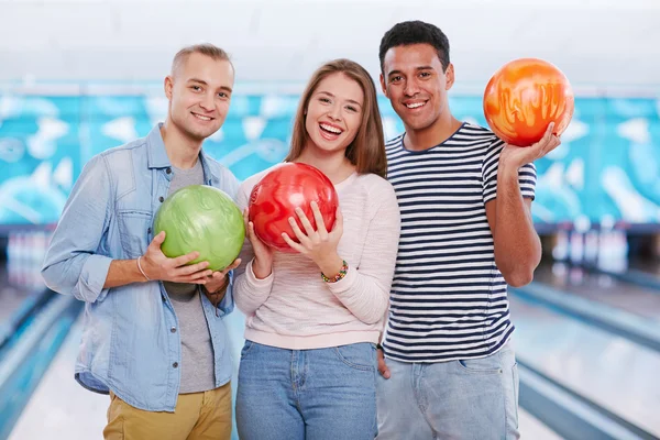 Guys and girl with bowling balls