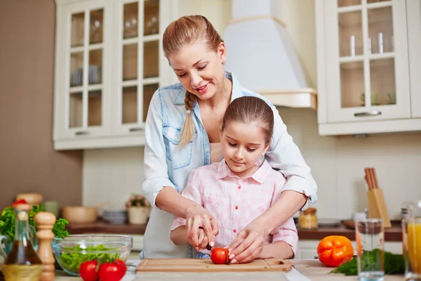 Woman and daughter cutting tomatoes