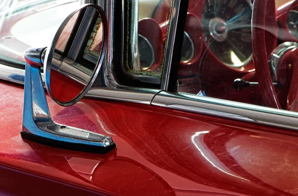 Part of the old red  car and car mirror
