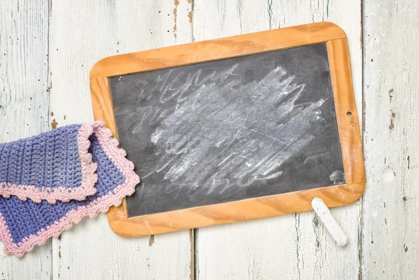 Old school blackboard with chalk and a cleaning cloth