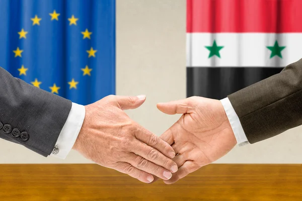 Representatives of the EU and Syria shake hands