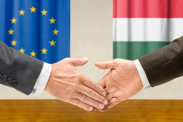 Representatives of the EU and Hungary shake hands
