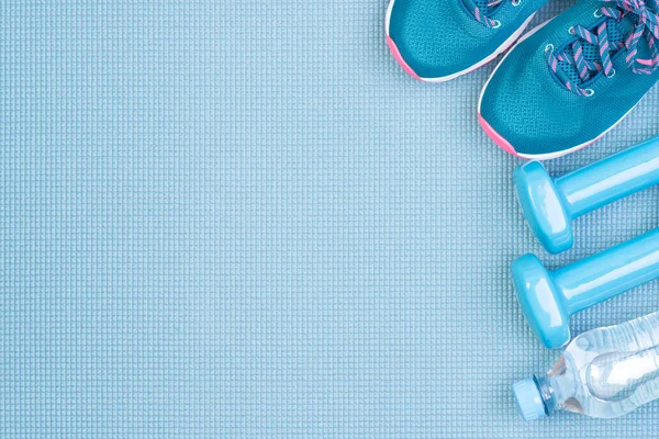 Fitness equipment on blue background with copy space