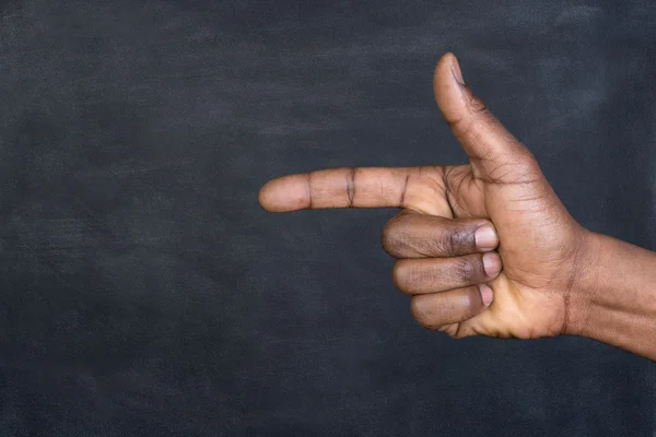 Male hand pointing a finger at copy space on a blackboard