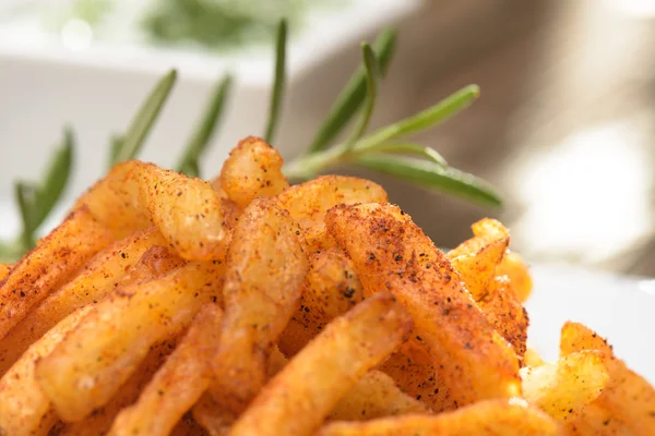 French fries and rosemary close up against blury background