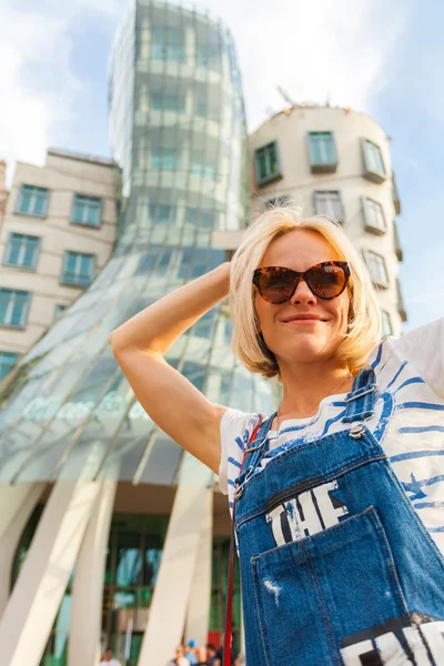 Blonde girl in front of the Dancing House. Prague.