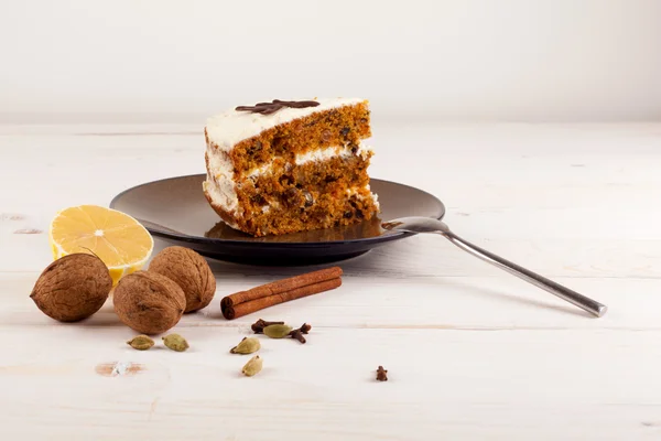 Piece of carrot cake with walnuts and white cream.